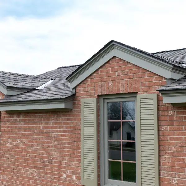 Red brick ranch home with a newly installed charcoal architectural shingle roof and sage trim.