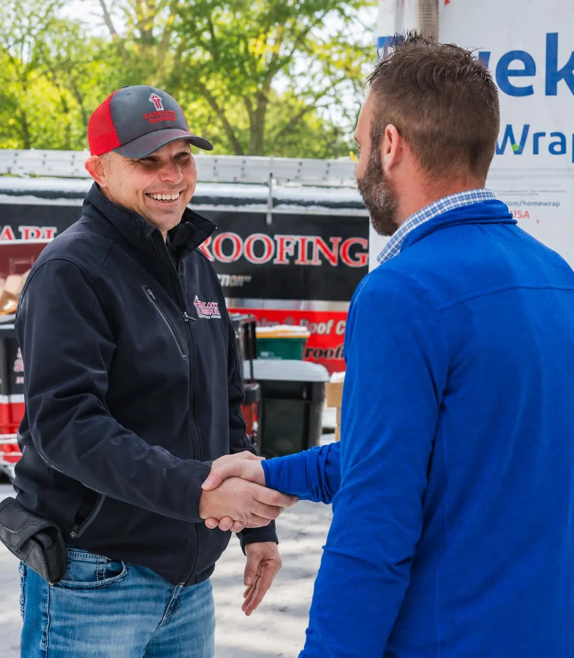 A Zablocki Roofing team member shaking hands with a satisfied customer